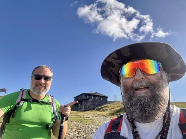 Due escursionisti e il rifugio sullo sfondo