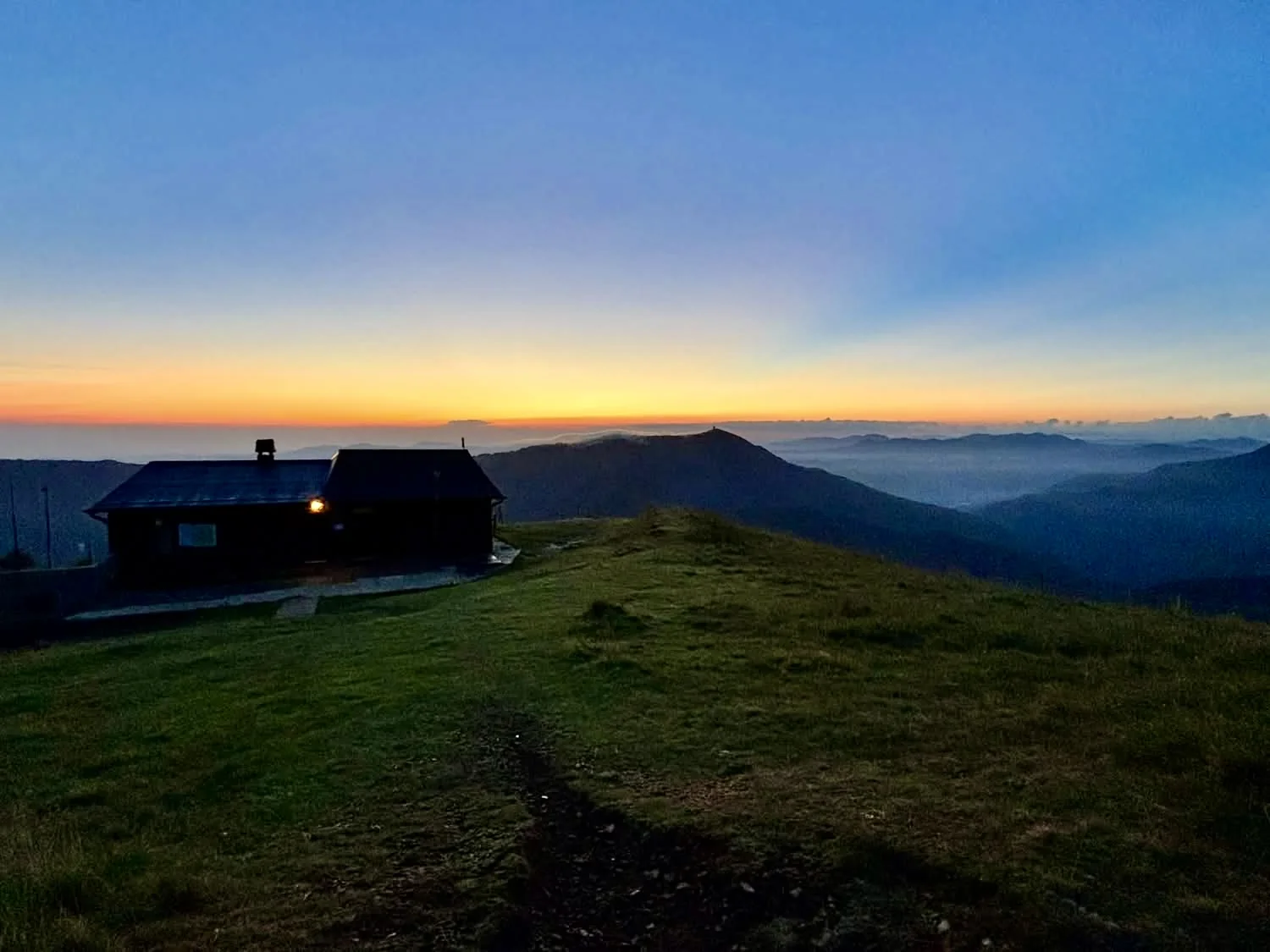 Il rifugio e il profilo dei monti nella luce della sera